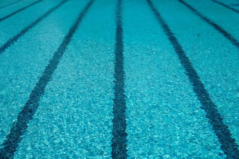 Clear blue swimming pool water over lane tiles