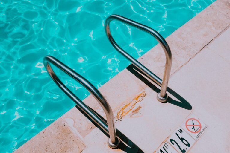 Swimming pool ladder beside blue water